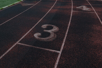 Running track lane 3 with white lines and markings on red rubber surface