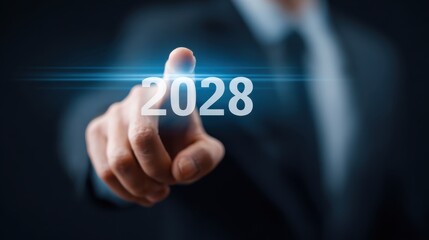 Obraz premium Professional man in suit pointing at futuristic year 2028 with focus and illumination, representing vision, technology, and future planning in business