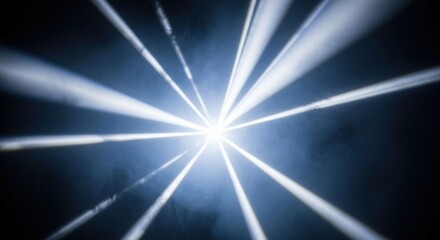 Central radiating beams of bright light against a dark background with haze