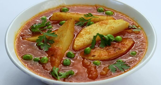 Potato curry or aloo or aaloo masala fry with green peas, indian main course food, selective focus