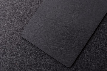 Fototapeta premium A black slate stone board or plate, an empty kitchen utensil. A black slate board