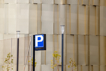 Parking Sign Against Gold-Toned Textured Facade