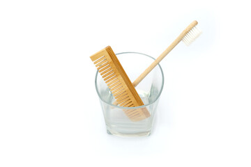 Natural Wooden Toothbrush and Comb in Glass Cup on White Background
