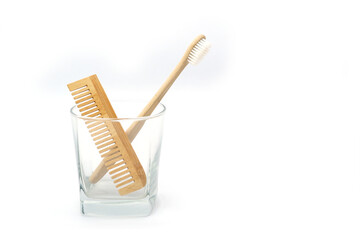 Natural Wooden Toothbrush and Comb in Glass Cup on White Background