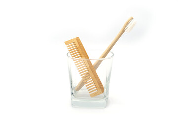 Natural Wooden Toothbrush and Comb in Glass Cup on White Background