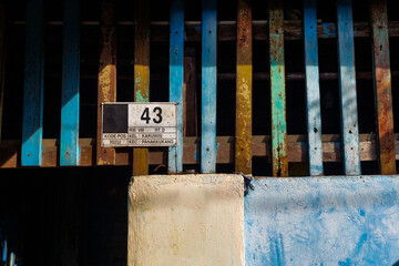 The wall of a slum house with the number 43, exposed to sunlight