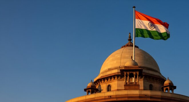Indian national tricolor flag flying proudly atop a historic domed building against a clear blue sky, symbolizing patriotism, sovereignty, national pride, democratic values, heritage architecture