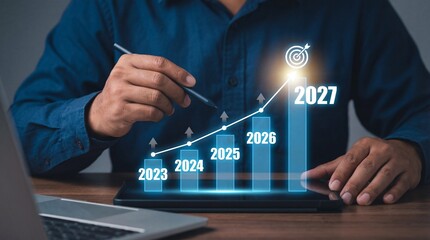 A businessman thoughtfully analyzing a digital graph projected from a tablet indicating growth and future planning with dates high quality