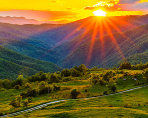 Vertical view of sunset sun rays over Sutjeska National Park, Bosnia and Herzegovina, lighting green mountain valley and meadows, dramatic golden hour wilderness landscape, travel background.
