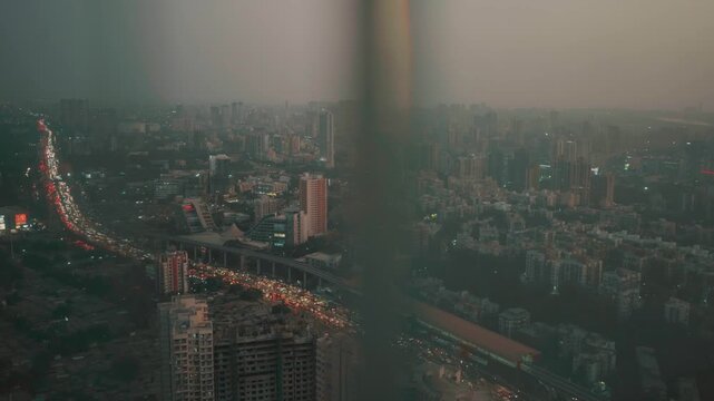 Evening view of a metropolis city from the top showing the cityscape, skyscrapers, houses, and traffic.