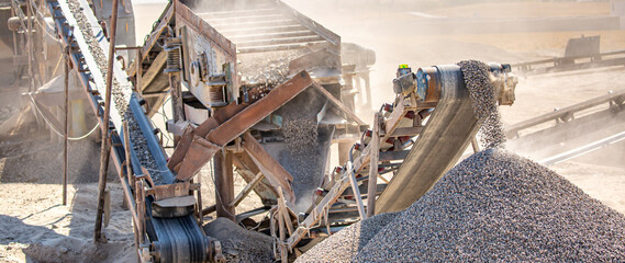 Vibrating screen stone crusher in operation. Crushing stones in a quarry for processing minerals,...