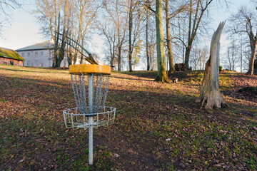 Disc golf target basket in a park setting near Vilce manor house