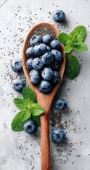 Blueberries, spoon, mint, & chia on mottled grey