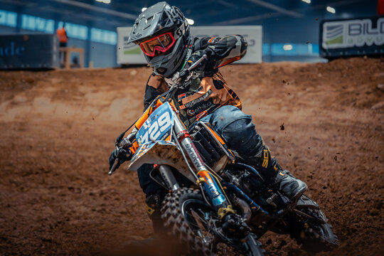 Latvia, Riga, 2025-08-27, regular training. Motocross rider in full gear racing on a dirt track with dust flying behind