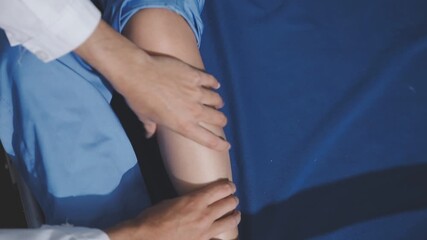 Asian physical therapist nurse is performing physical therapy to rehabilitate the legs of an elderly female patient.
