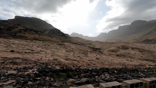 Descending Monte Verde and crossing dry river on S&atilde;o Vicente Island, Cape Verde on road with stone wall