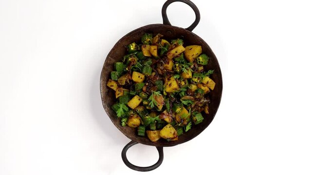 Indian style Masala Sabji OR Sabzi of fried Bhindi OR Okra also known as Ladyfinger, Served in a bowl over moody background. selective focus

