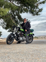 Man riding a custom cafe racer motorcycle on an open road during a journey, enjoying freedom, travel adventure, and the sense of destination while exploring landscapes on a motorbike trip