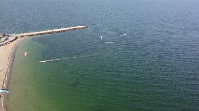 People in sportswear on kiteboards ride on the Black Sea in Bulgaria