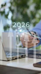 Vertical of Businesswoman selecting 2026 on virtual screen in office representing successful business prediction or forecast for next year