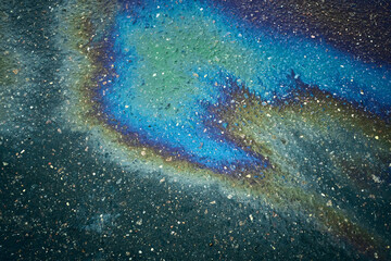 Diverse oil stain on the asphalt road, resulting in a captivating abstract pattern.
