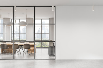 Modern office interior with glass wall meeting room and large blank white wall for poster or canvas...