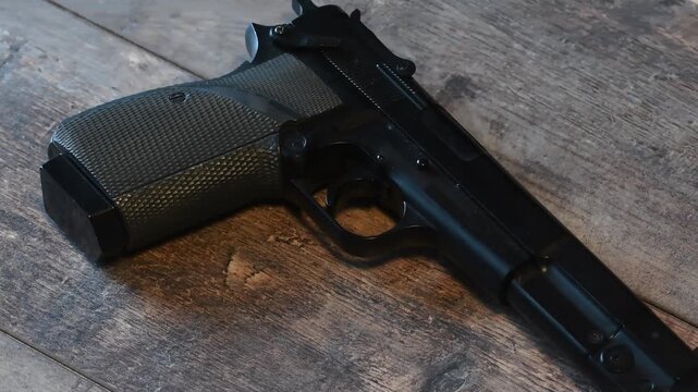 Hand places gun on table in indoor setting