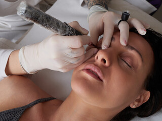 professional tattooist making permanent make up