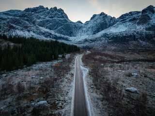 Lonely Mountain Road Leading Into a Snowy Valley in Northern Norway