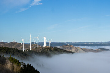 wind turbines in mountains with clouds on bottom