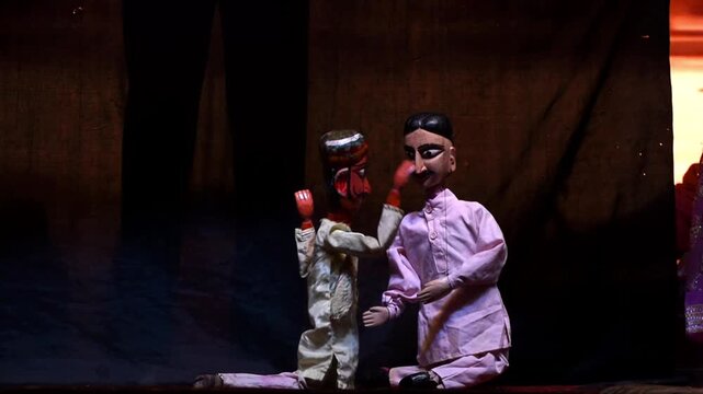 kathputli puppets of two male characters dancing and interacting on a stage during a folk puppet show