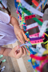 Fototapeta premium Close-up of hands on a grid with ribbons and a rosary