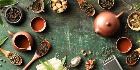 Tea Leaves and Teaware Flat Lay with Rustic Green Background