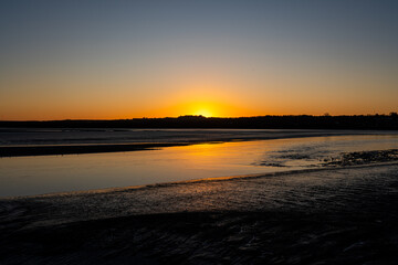 Fototapeta premium Sunrise over the River Mersey at low tide with exposed sandbanks and calm flowing water