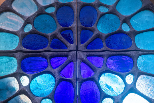 Dettaglio della vetrata dai colori blu e acquamarina di una cappella nel cimitero di Murano a Venezia 