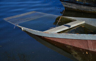 Abandoned rowing boat filled with water and sunken near the lake shore © Dmytro