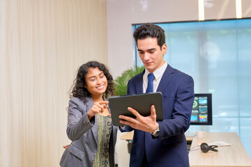 Business working team with businessman and woman smile for discuss with tablet information in co working space area for show benefit.