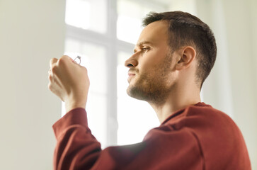 Focused young man examining expensive diamond ring, evaluating gemstone value. Expert appraiser analyzing details, checking clarity, quality and authenticity, showcasing expertise in jewelry repair.