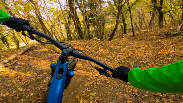 POV: Speeding along a cool mountain biking track in the vibrant fall forest. Cool action first person shot of riding a mountain bicycle along a downhill trail in the picturesque autumn woodlands. - Powered by Adobe