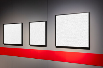 Tre cornici rettangolari su parete grigia, con superficie bianca adatta a testo o immagini. Ripresa in prospettiva. Una striscia orizzontale rossa audace attraversa la parte inferiore della parete. © massimo_g