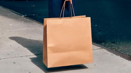 Eco‑friendly brown paper shopping bag on pavement in morning light, minimalist lifestyle concept for sustainability, retail and conscious consumerism