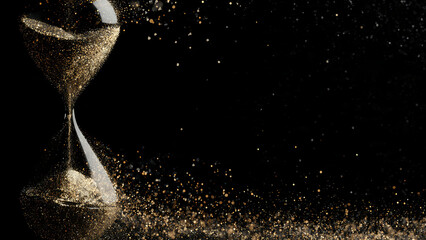 Golden hourglass with sand pouring against black background