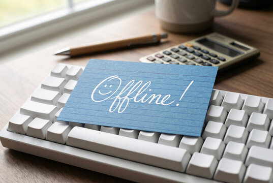 Blue note card with offline message on computer keyboard, digital detox and work life balance office concept.