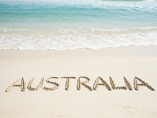 Fototapeta premium Beach scene with australia written in sand on shore
