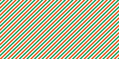 Christmas seamless pattern. Red and green diagonal stripes background. Candy cane repeating decoration wallpaper. Winter holiday lines backdrop.
