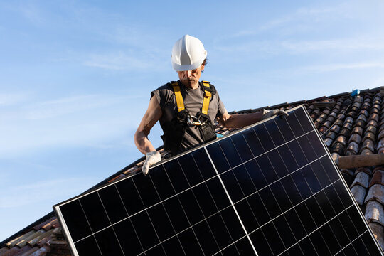 Roofer Installing Solar Panel on Residential Clay Tile Roof