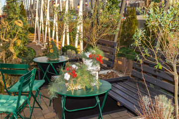 An outdoor caf&eacute;. On a green table are New Year's decorations with fir branches and red viburnum.