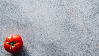 石目調の背景に置かれた一粒の赤いトマト