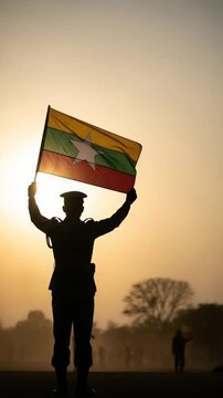 Silhouette of Male Soldier Holding Myanmar Flag at Sunset in Peaceful Protest