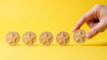 Hand placing wooden star rating token on bright yellow background